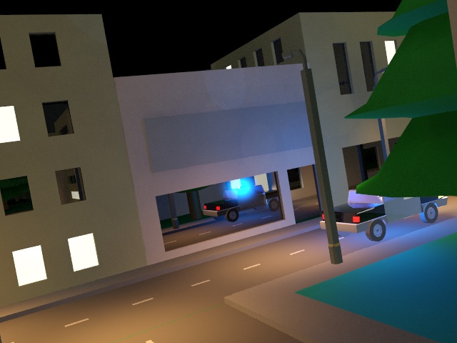 A police car drives through a town.